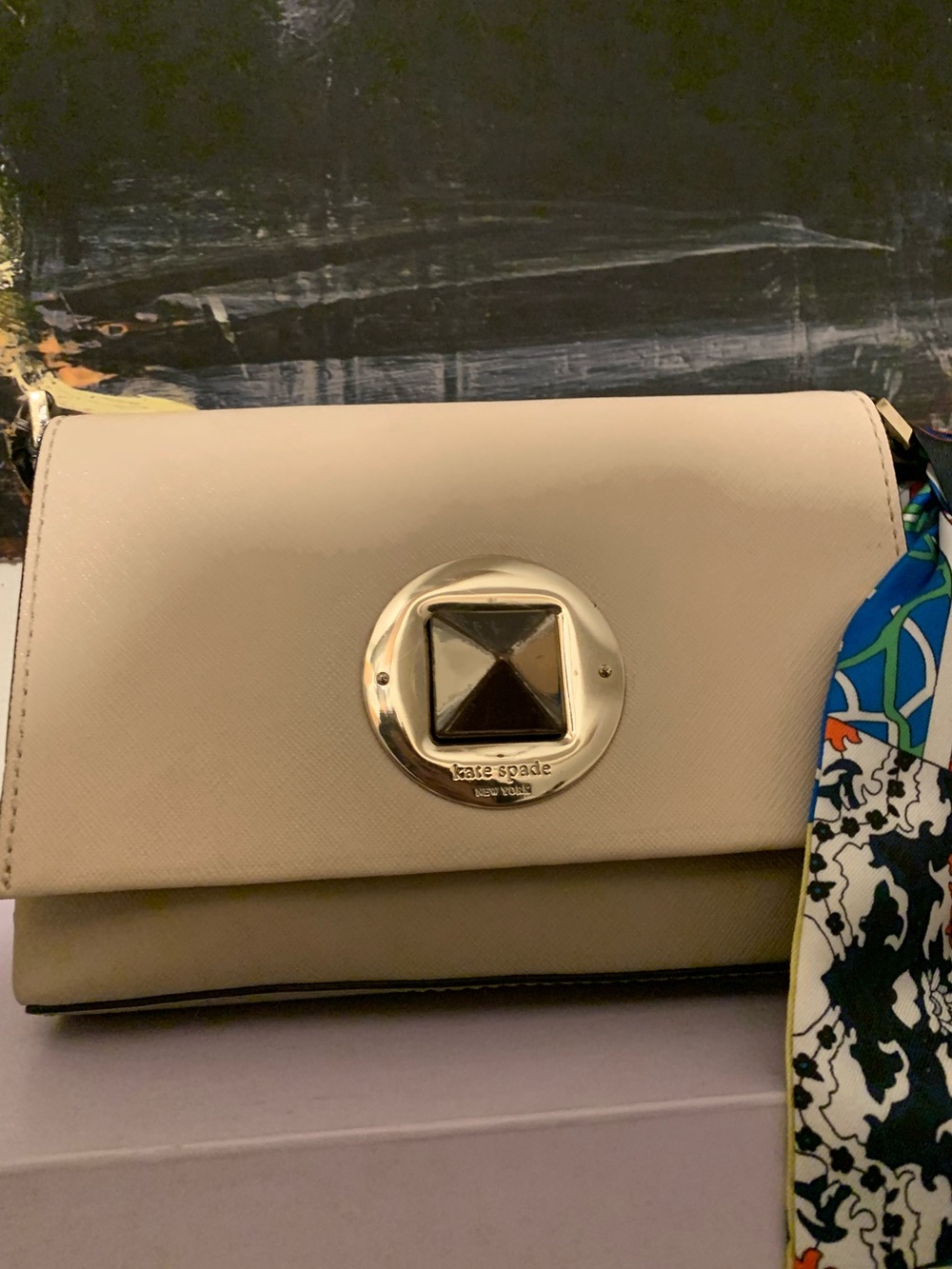 kate spade cream crossbody with gold medallion and patterned scarf